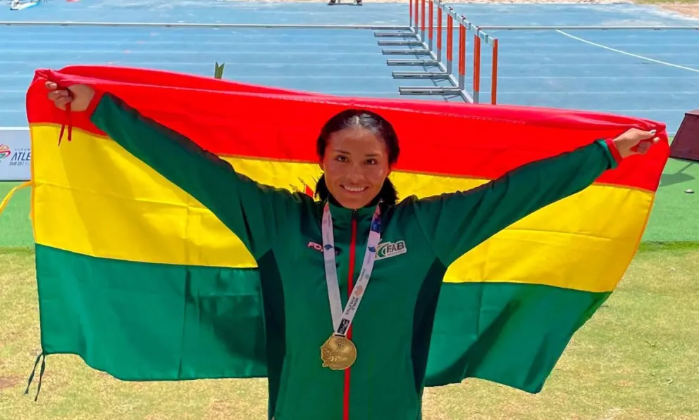 Parra con su presea dorada y la tricolor nacional. Foto: Federación Atlética de Bolivia.