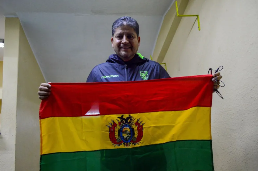 El DT Villegas sostiene la tricolor nacional tras la rueda de prensa. Foto: Alejandro Apaza.