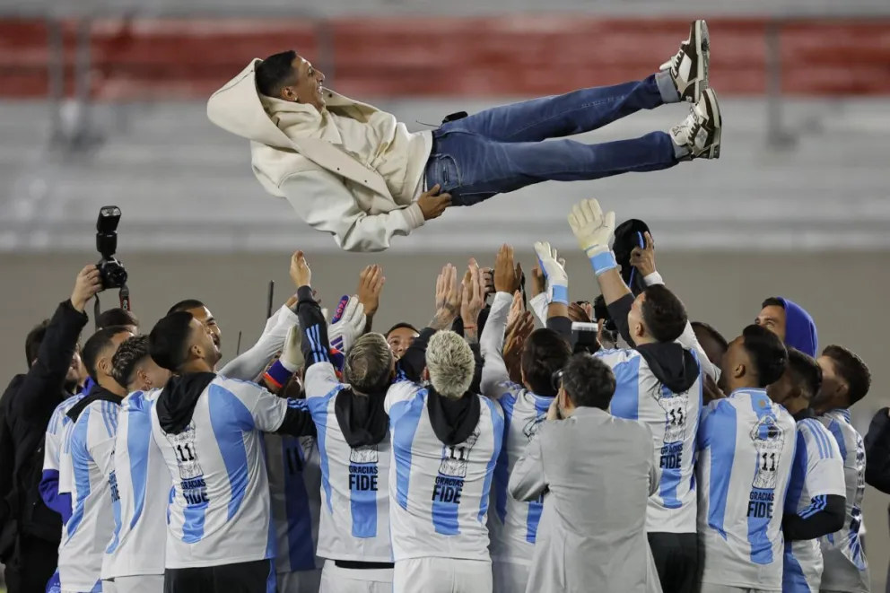 Jugadores de Argentina lanzan a Ángel Di María en la tradicional “manteada” previo al partido con Chile por las eliminatorias. Foto: EFE