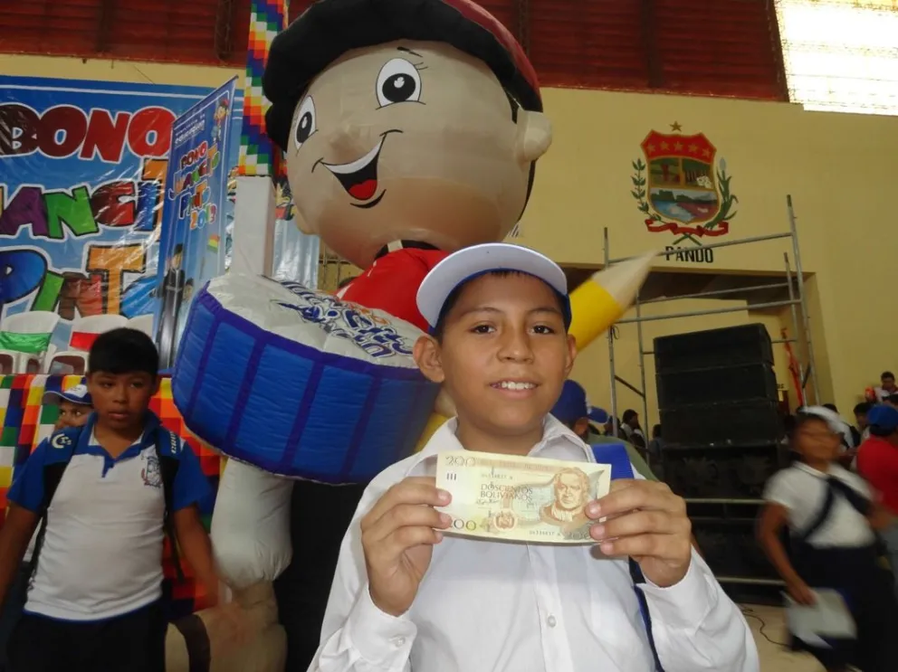 Un estudiante que recibió el bono Juancito Pinto muestra su billete. Foto: ABI