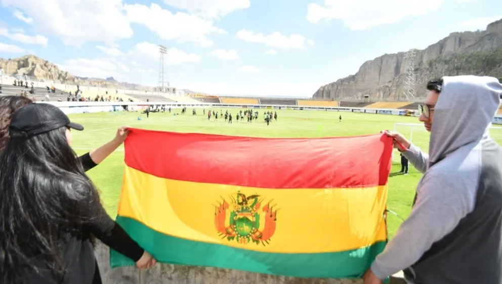Dos hinchas sostienen una bandera boliviana, durante el entrenamiento de la Selección en Achumani. Foto: APG