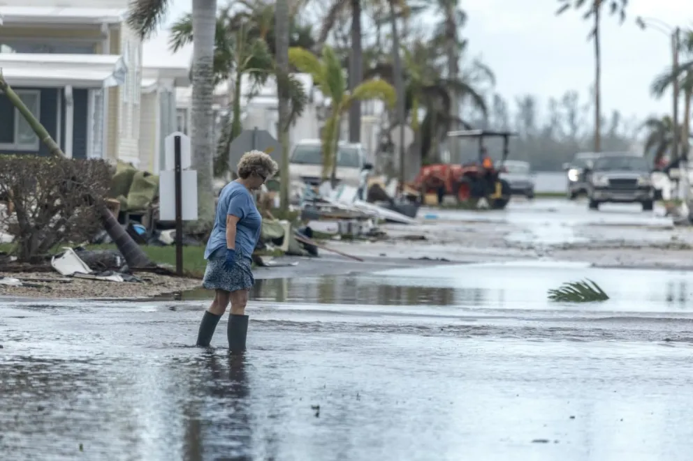 Una mujer camina por una calle inundada tras el paso del huracán Milton en Bradenton, Florida. Foto: EFE