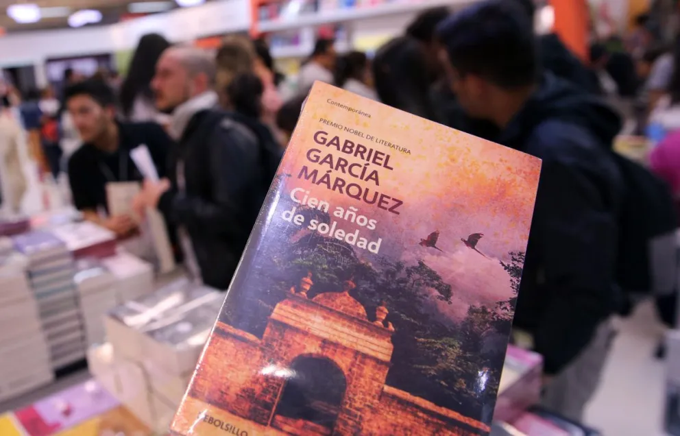 Foto del 30 de abril de 2017 de asistentes a la XXX Feria Internacional del Libro de Bogotá mientras observan el libro "Cien Años de Soledad", de Gabriel García Márquez, en Bogotá (Colombia). Foto: EFE