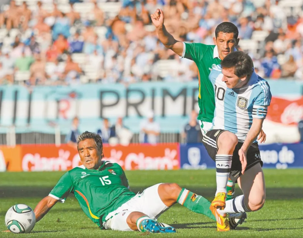 Lionel Messi (10) intenta superar la marca de Jaime Robles (15) y Wálter Flores en un partido anterior entre Argentina y Bolivia. Foto: TyC
