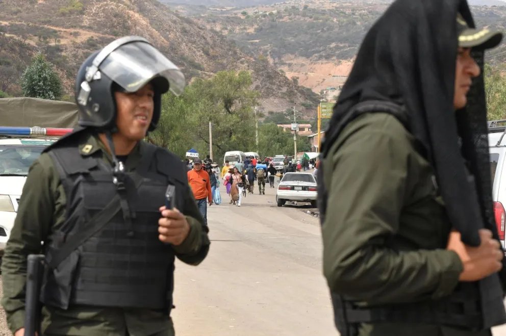 Policías vigilan una vía bloqueada durante la tercera jornada de protesta por parte de seguidores del expresidente Evo Morales, este miércoles en Parotani. Foto: EFE