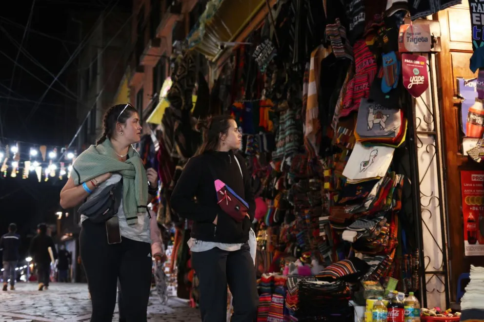 Turistas pasean en el sector conocido como el Callejón de las Brujas, en el centro de la ciudad de La Paz (Bolivia). Foto: EFE / Luis Gandarillas