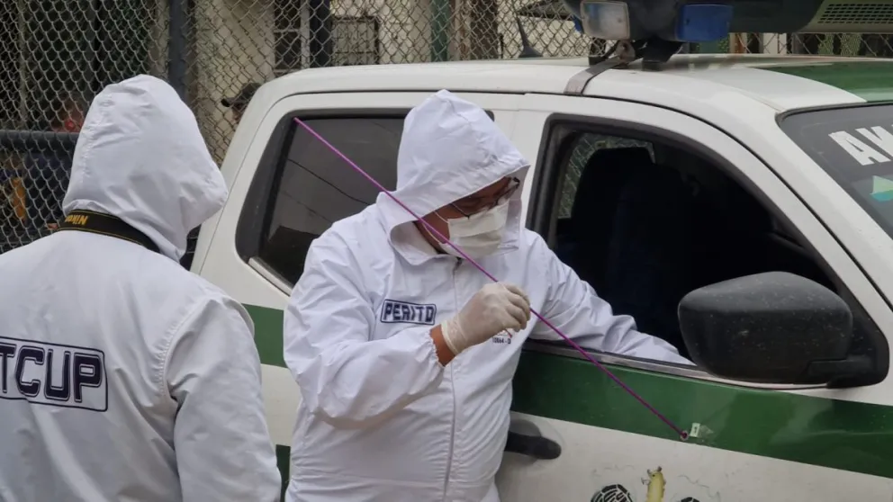 Peritos toman pruebas en la patrulla que fue atacada en el bloqueo. Foto: APG