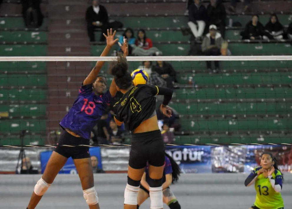 Una jugadora de San Martín (de negro) hace un mate ante el bloqueo de su rival. Foto: APG.