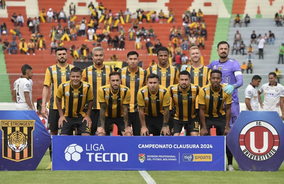 Formación inicial de The Strongest en el partido frente a FC Universitario. En las tribunas se observa a una parte de los hinchas aurinegros. Foto: APG
