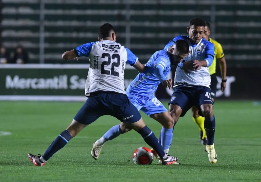 Melgar (centro), de Bolívar, trata de superar la marca de dos rivales. Foto: APG.