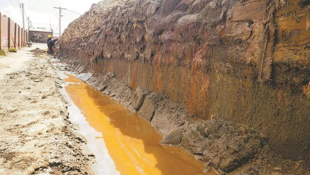 Obreros reparan un muro de un estanque de agua con filtraciones de copajira, usado por una empresa minera en Viacha. Foto: Carlos Quisbert