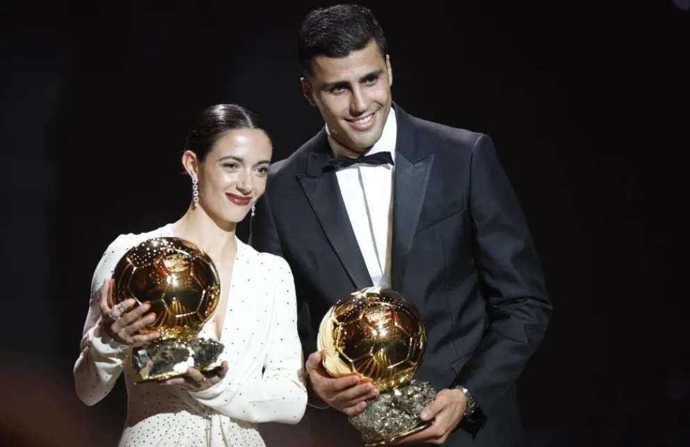 Los españoles Aitana Bonmatí (izq.) y Rodrigo Hernández posan con sus trofeos tras ser declarados como los mejores futbolistas. Foto: EFE