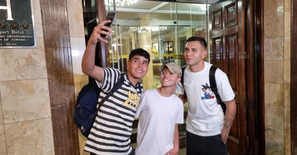 Héctor Cuéllar (der.) se saca una selfie con dos hinchas. Foto: Marcelo Avendaño.