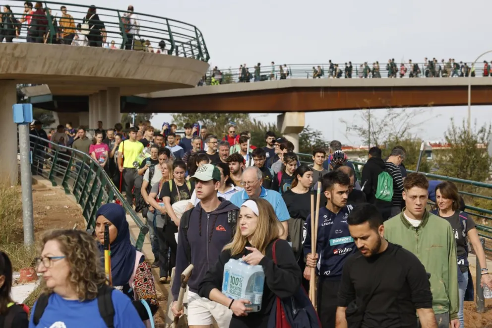 Miles de personas se desplazan caminando desde Valencia hacia los municipios limítrofes para ayudar a los afectados. Foto: EFE