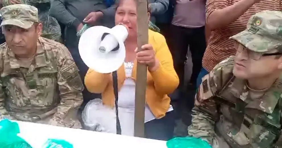 Dos militares con la dirigente cocalera, en las afueras de la Novena División del Ejército. Foto: Captura de video