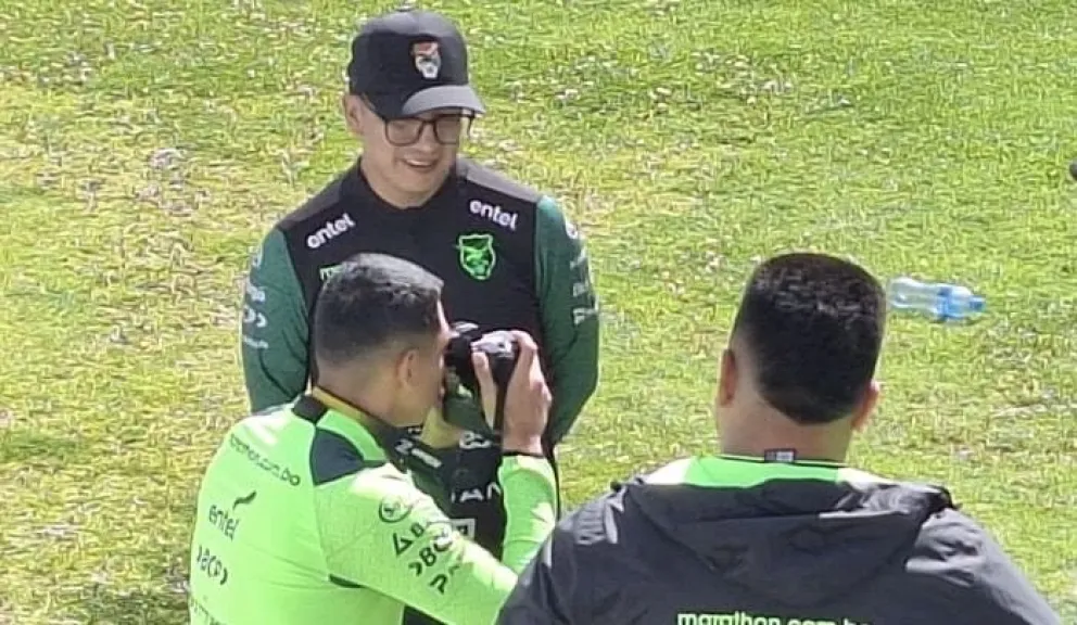 Martines hace de fotógrafo mientras sus compañeros trabajan en cancha. Foto: Jorge Asturizaga.