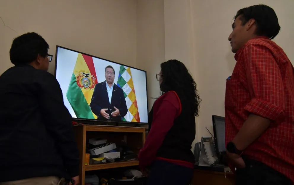Personas ven a Luis Arce durante un mensaje al país. Foto: APG