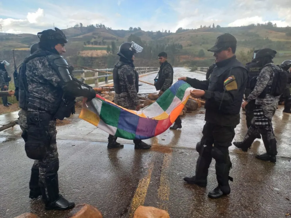 Efectivos policiales recuperan una wiphala que fue dejada por los bloqueadores. Foto: Facebook Eduardo Del Castillo