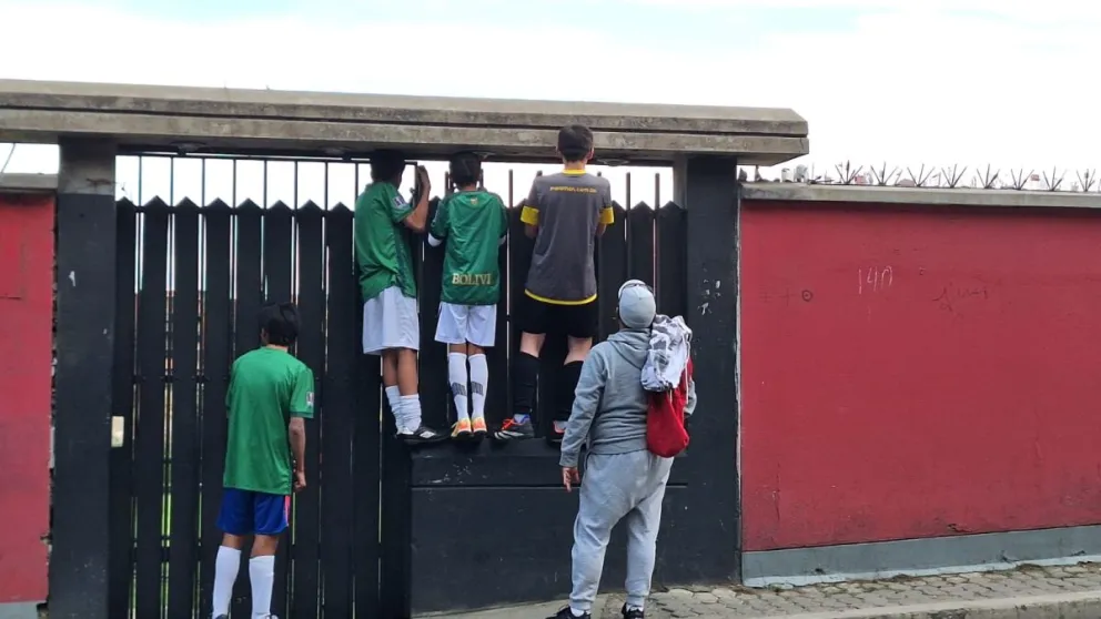 Chicos se treparon en una de las puertas del Centro Cervecero para ver el trabajo de la Verde. Foto: Jorge Asturizaga