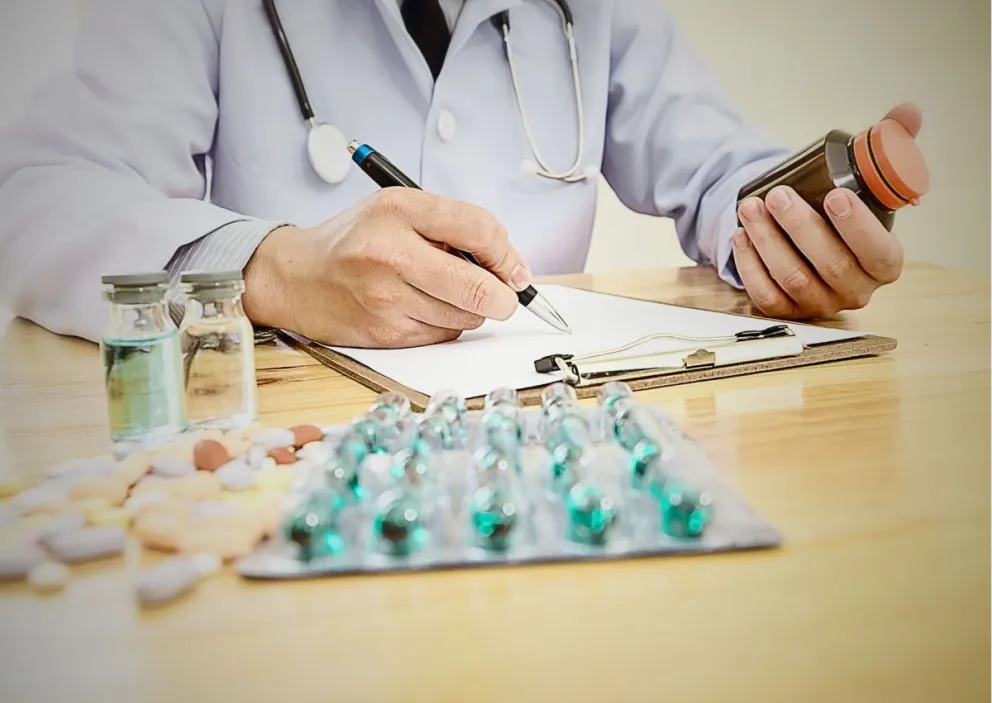 Un doctor junto a medicamentos (imagen referencial)