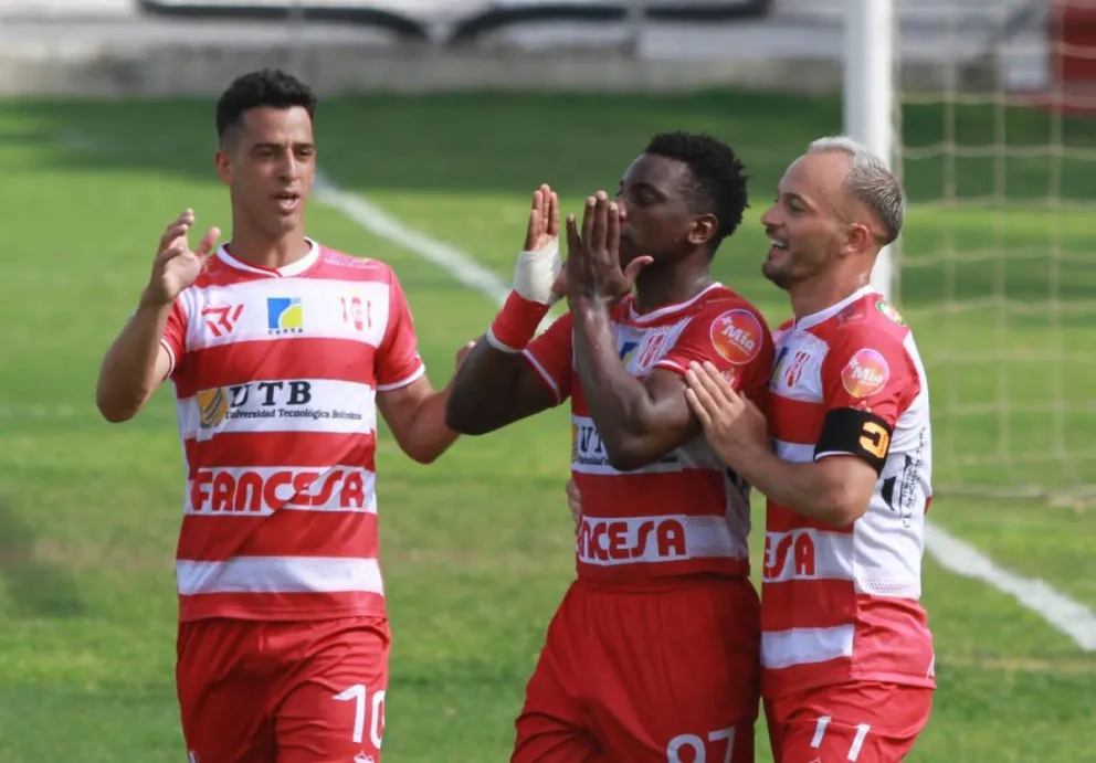 Daniel Porozo (centro) es felicitado por sus compañeros Thomaz Santos (izq.) y Juan Godoy después de convertir el segundo gol. Foto: APG