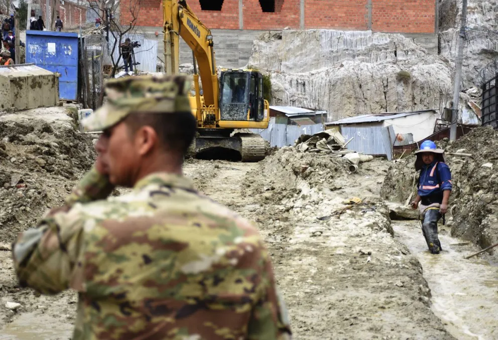 Un efectivo y un trabajador municipal en las labores que se realizan en la zona afectada. Foto: APG 