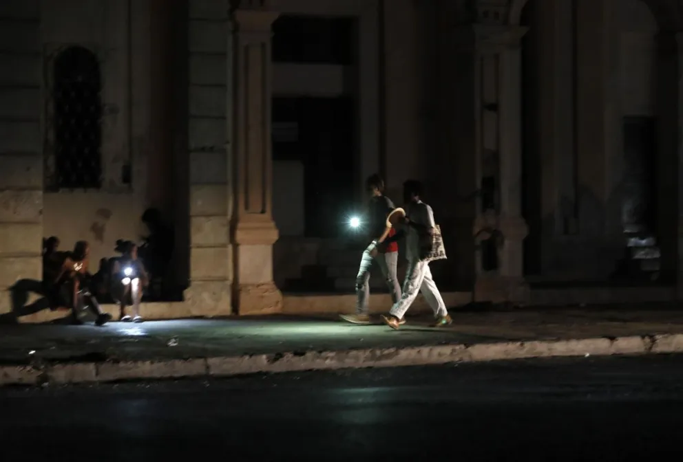 Personas caminan por una calle sin iluminación auxiliándose con la luz de su celular durante un apagón, el 18 de agosto de 2022, en La Habana (Cuba). Foto: EFE