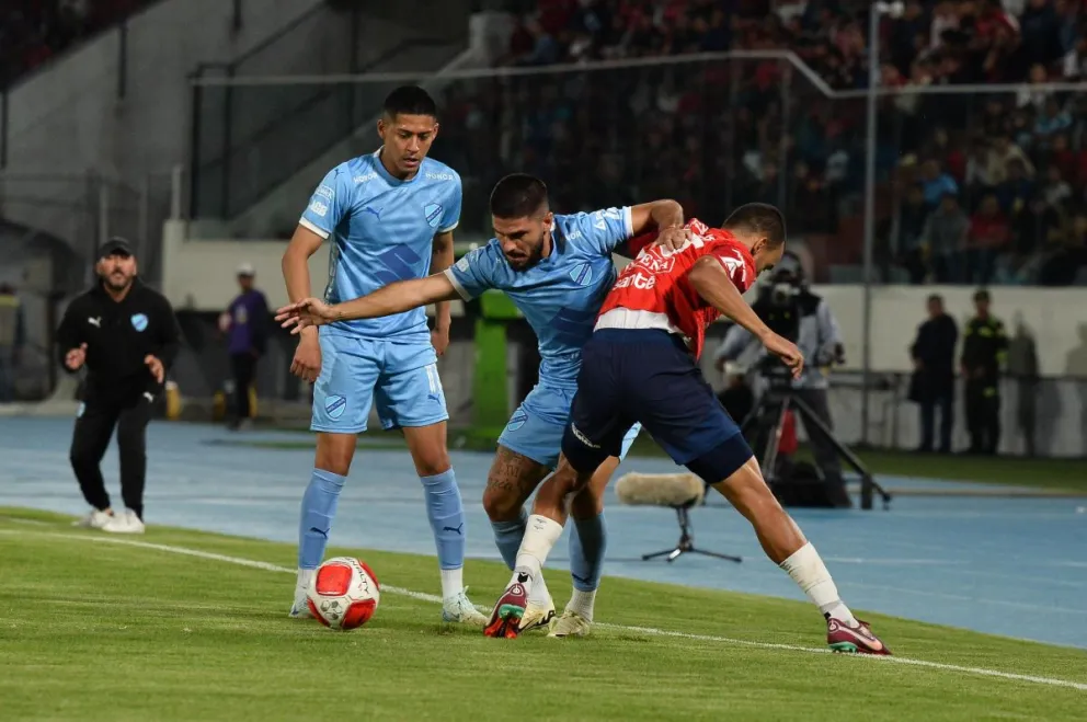 El jugador de Bolívar, Carlos Melgar, trata de superar la marca de un rival. Foto: APG.
