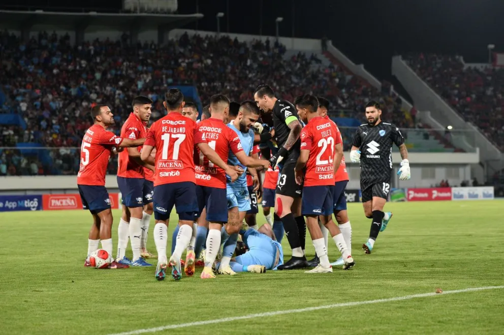 Orihuela tendido en el césped tras recibir el manotazo y que derivó luego en su primera amarilla. Foto: APG.