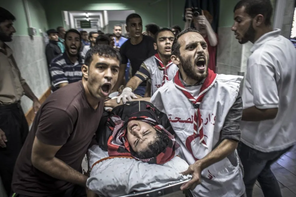 Miembros de la asistencia de primeros auxilios cuando ayudaron a un herido, en el hospital de Kamal Adwan en Gaza. Foto: EFE