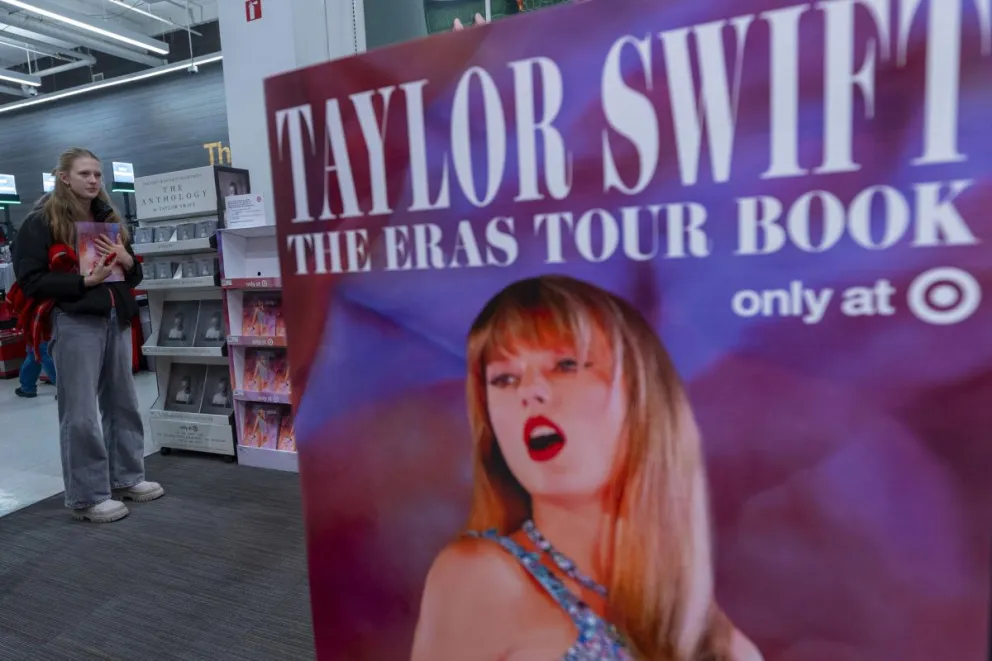 Una mujer sostiene una copia del libro "The Eras Tour Book" de la cantante estadoundiense Taylor Swift, en Nueva York. Foto: EFE