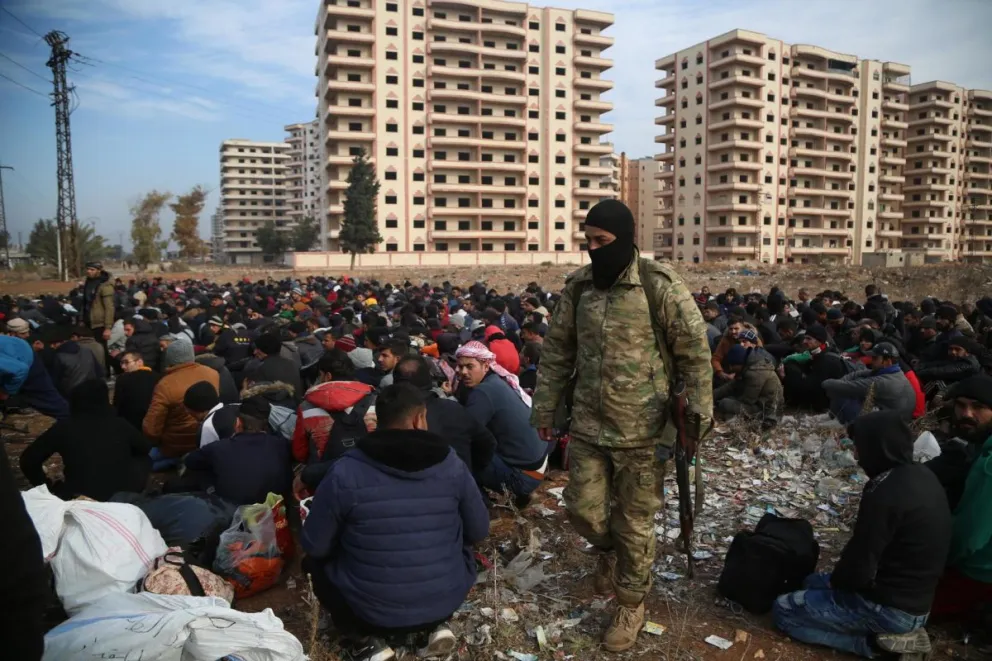 Foto de archivo que muestra a miembros de las fuerzas de seguridad del gobierno sirio detenidos y reunidos en un campo custodiados por soldados rebeldes en la ciudad de Homs el domingo 8 de diciembre. Foto: EFE