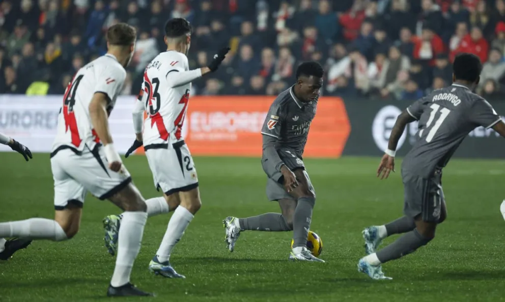 Vinicius Junior, del Real Madrid, controla la pelota rodeado por jugadores del Rayo y su compañero Rodrygo. Foto: EFE