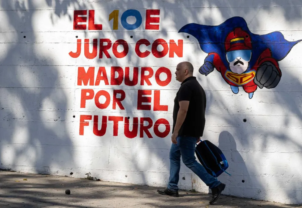 Un hombre camina frente a un mural con el mensaje "El 10E juro con Maduro por el futuro" este viernes, en Caracas (Venezuela). Foto: EFE