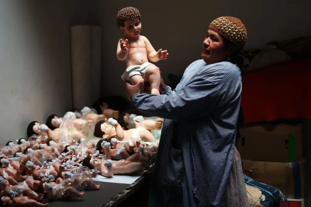 Fotografía del 10 de diciembre de 2024 de Olma Nina sosteniendo una imagen del Niño Jesús en el taller 'Alaski' en El Alto (Bolivia). Foto: EFE