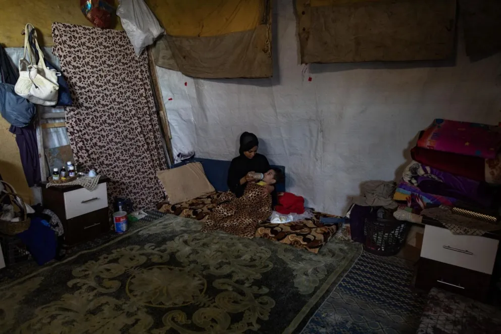 Una madre palestina desplazada cuida de su hijo en su hogar en un campamento para personas desplazadas en Khan Yunis, Gaza. Foto: EFE