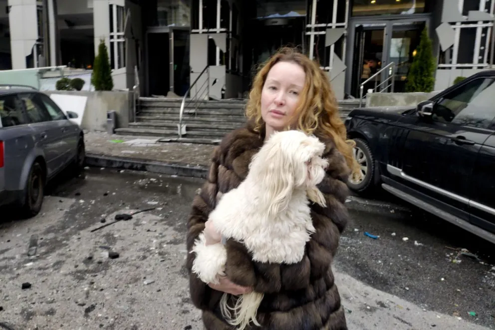 Yulia Levchenko sostiene a su perro en brazos después de que el hotel en el que se alojaba sufriera daños en una explosión provocada por misiles rusos. Fotos: EFE
