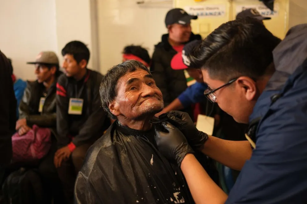 Un hombre recibe un corte de pelo y una afeitada durante una jornada de ayuda a personas en condición de calle, este viernes en La Paz. Foto: EFE