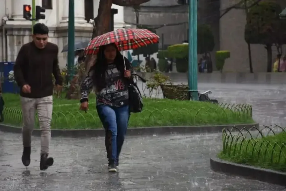 Dos personas transitan por el centro de la urbe mientras llueve (imagen referencial). Foto: AMUN