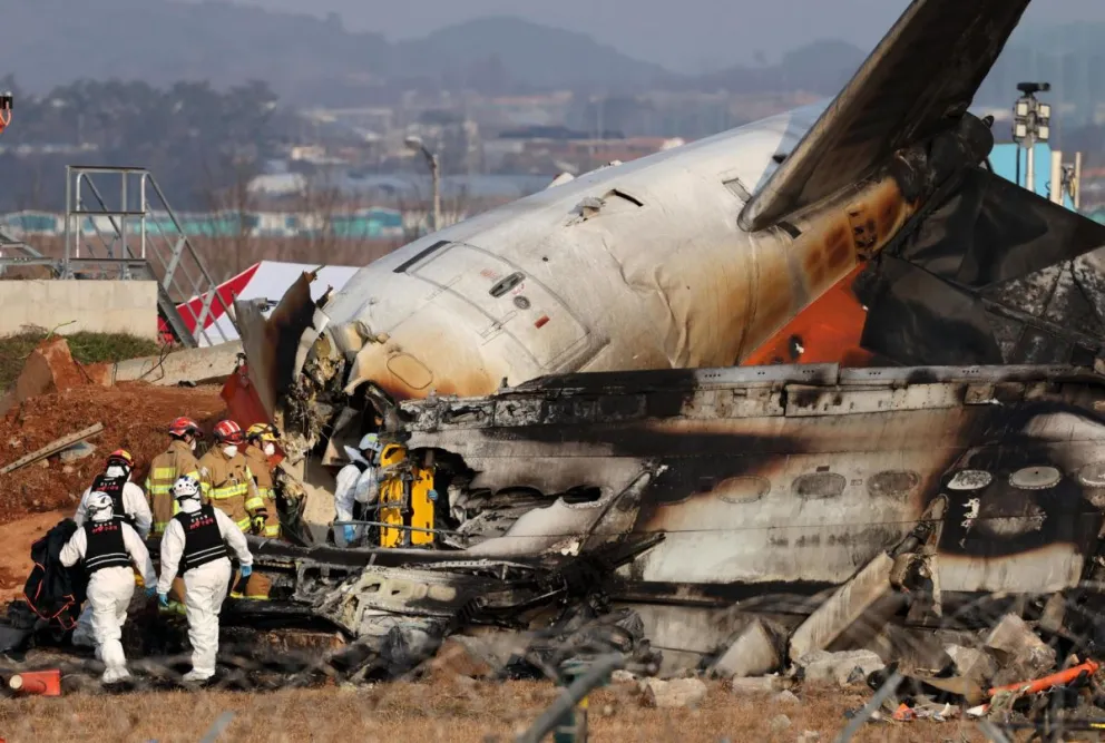 Los bomberos trabajan en los restos del avión Jeju Air siniestrado este domingo en el aeropuerto surcoreano de Muan. Foto: EFE