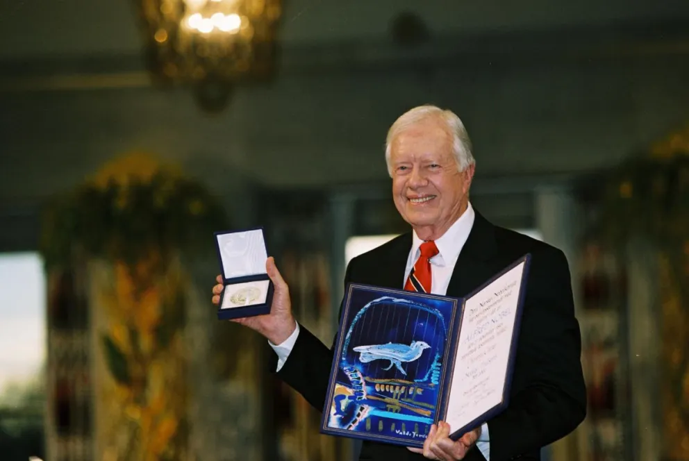 Imagen cedida por la Fundación Carter del expresidente de Estados Unidos Jimmy Carter, posando con el Premio Nobel de la Paz en 2002. Foto: EFE