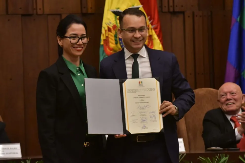 La voval del TSE Yajaira San Martín entrega la credencial al juez Romer Saucedo, electo para el TSJ. Foto: APG
