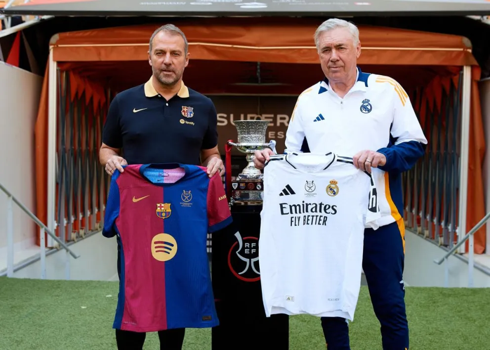 Los entrenadores del Barcelona, Hansi Flick (izq.) y del Real Madrid, Carlo Ancelotti, posaron el sábado junto al trofeo. Foto: EFE