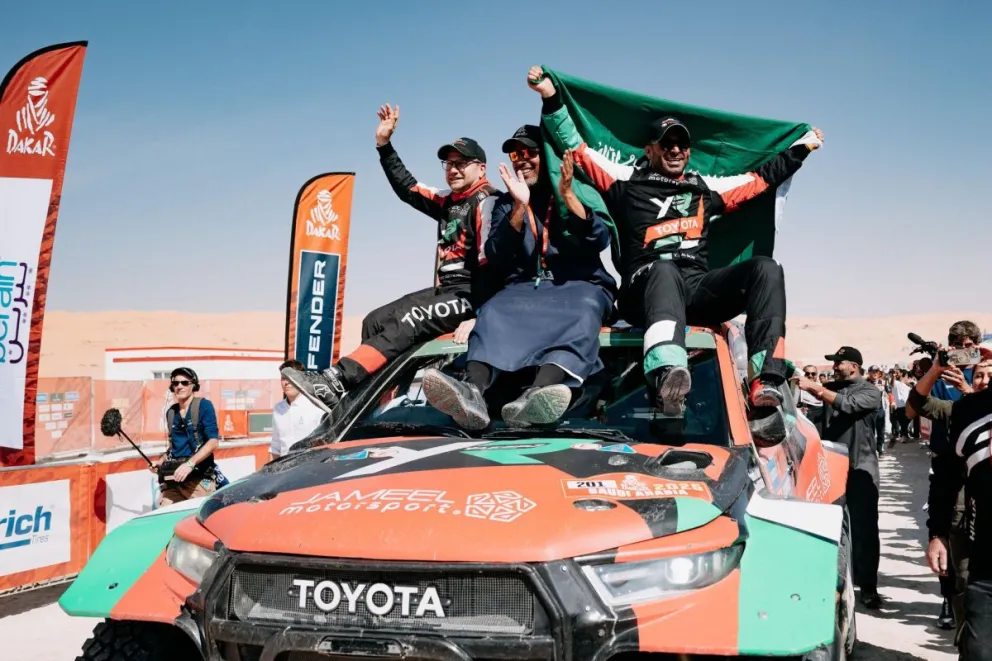 El saudí Al Rajhi sostiene la bandera de su país junto a su equipos tras vencer en los coches. Foto: Rally Dakar.