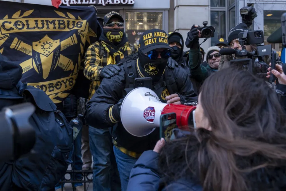 Integrantes de Proud Boys enfrentan a una mujer opositora durante la investidura de Trump. Foto: EFE