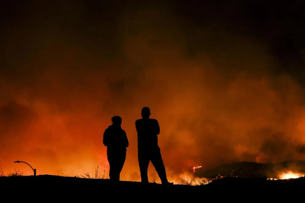 Dos personas observan los incendios en Los Ángeles. Foto: EFE