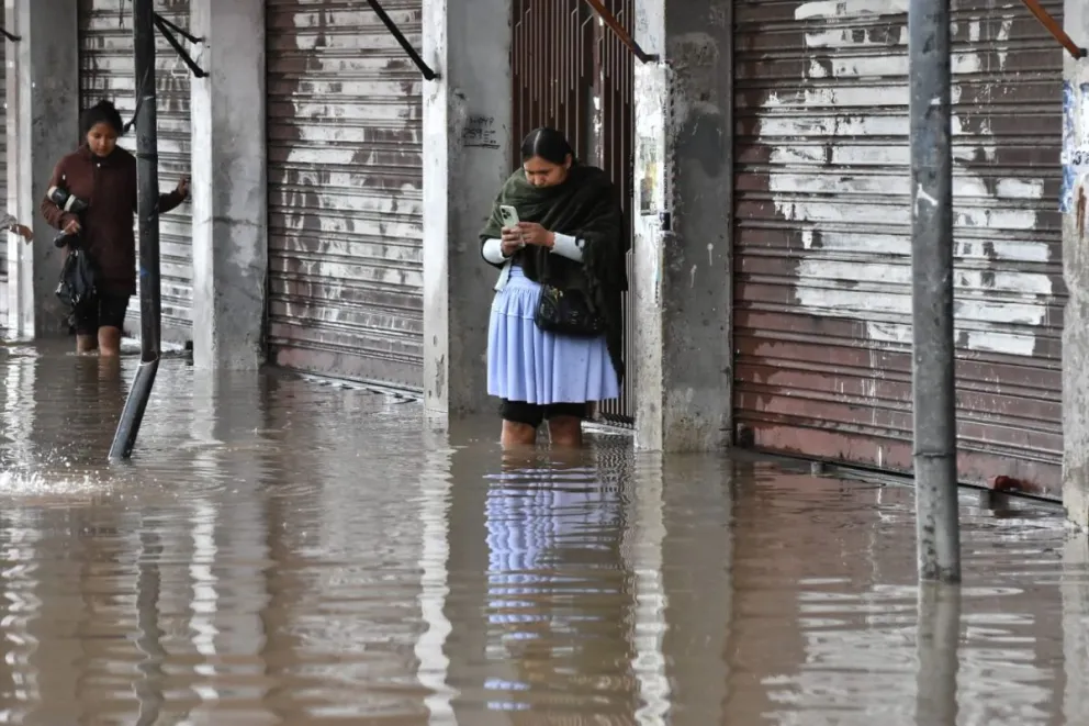 La calle Esteban Arce en Cochabamba  quedó inundada por las fuertes lluvias, el agua toca la rodillas de los ciudadanos. Foto: APG