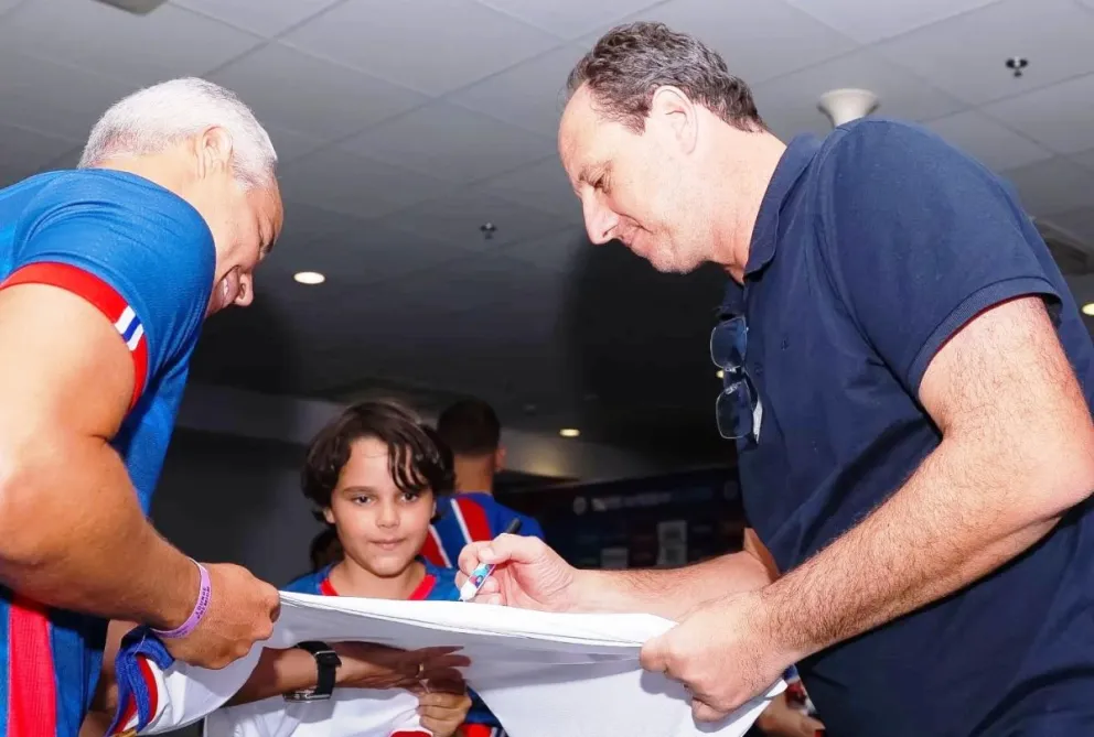 El DT Rogerio Ceni, a la derecha, firma una camiseta a un hincha del Bahía. Foto: Bahía