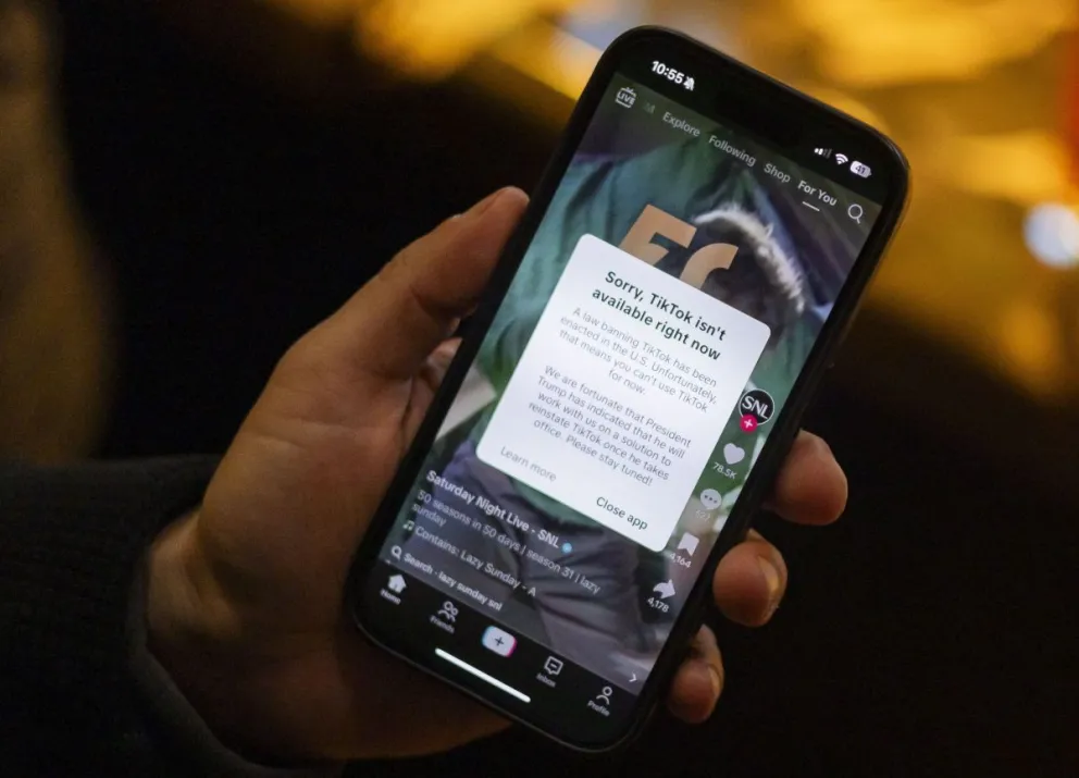 Una persona sostiene un teléfono con un mensaje en su aplicación de TikTok indicando que no está disponible en Washington el 18 de enero. Foto: EFE