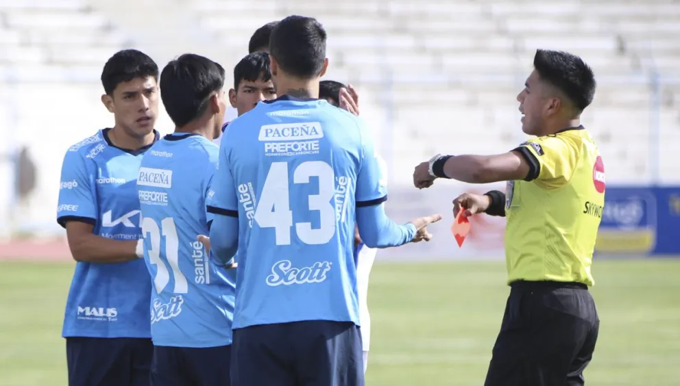 Jugadores de Blooming se aproximan al árbitro para reclamar una sanción en un partido de 2024. Foto: APG